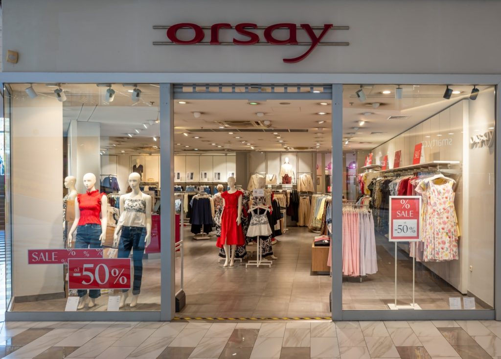 Obchod Orsay s výlohou, figuríny a slevové cedule