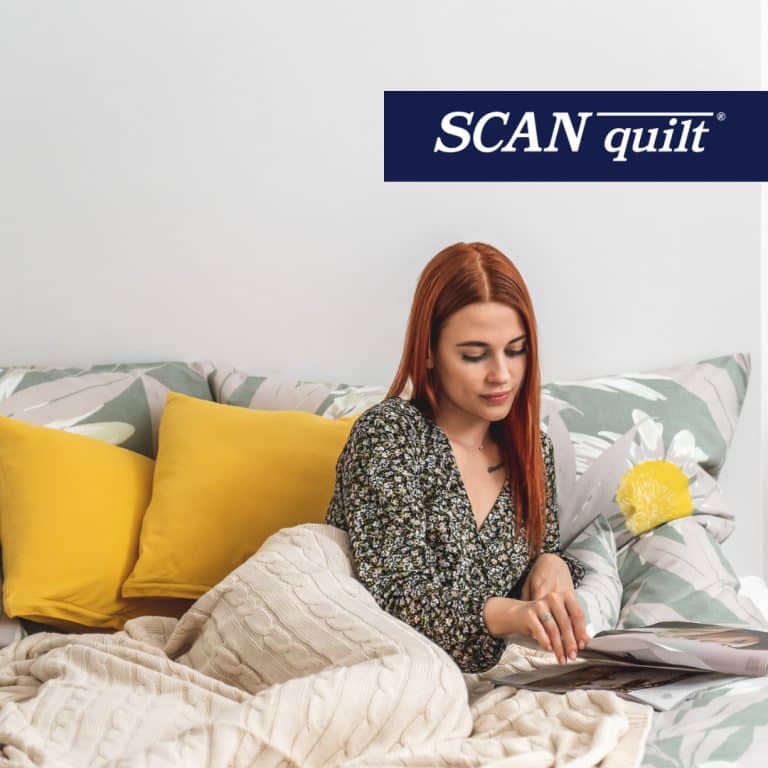 Žena v posteli s časopisem, žluté polštáře kolem ní