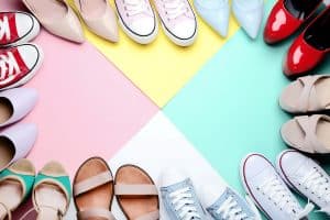 Různorodé boty uspořádané do kruhu na barevném pozadí