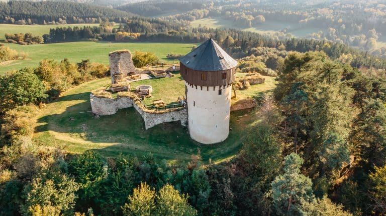 Starobylá věž a zřícenina hradu obklopená lesy