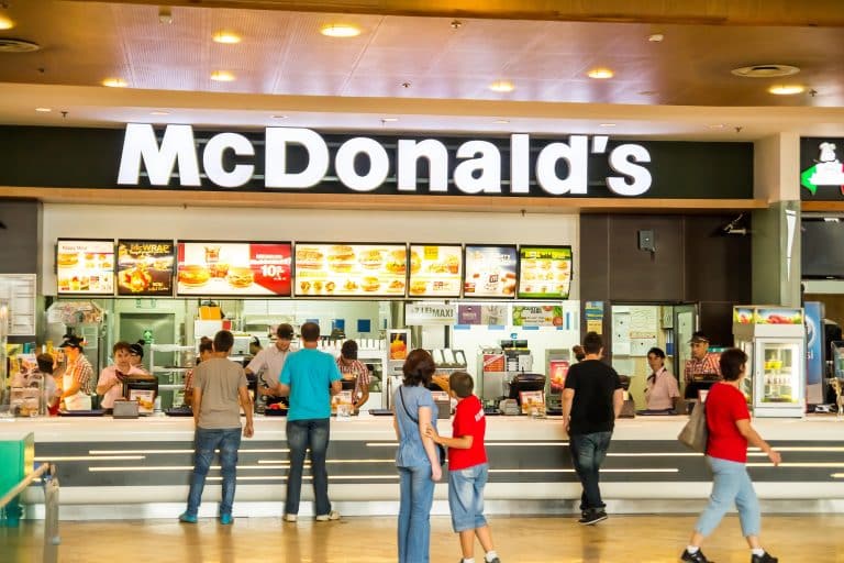 Lidé objednávají jídlo u pultu McDonald's restaurace