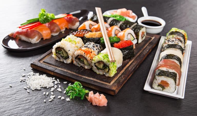 Talíře s různými druhy sushi, sójová omáčka a rýže