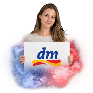 Žena drží ceduli s logem dm drogerie, na pozadí barevné kouřové efekty.