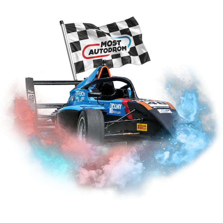 Modrá závodní formule s kouřovými efekty a šachovnicovou vlajkou Autodromu Most v pozadí.