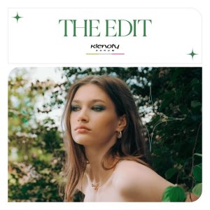 Mladá žena s jemnými šperky z nové kolekce The Edit od Klenot Aurum, obklopená zelení.
