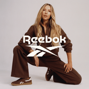 Žena v hnědé sportovní soupravě s logem Reebok